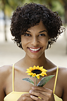 woman holding yellow sunflower and smiling - Alex Mares-Manton