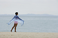 Woman wearing blue scarf looking at ocean. - Alex Mares-Manton