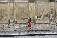 young woman walking down the street in a red dress - Alex Hajdu