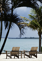 wooden beach chairs on sand overlooking the ocean - Alex Mares-Manton