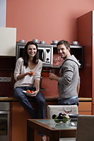 young couple standing in kitchen cooking and smiling - Alex Mares-Manton