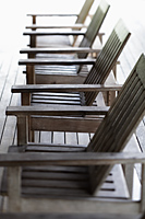 row of wooden chairs on deck - Alex Mares-Manton