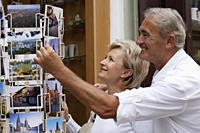 mature couple looking at postcards - Alex Hajdu