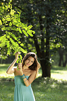 young woman holding leaves of tree and smiling - Alex Mares-Manton
