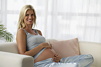 pregnant woman with hands on belly smiling - Alex Mares-Manton
