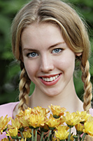 Head shot of young woman holding flowers - Alex Mares-Manton