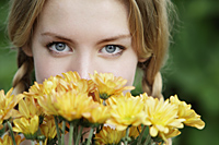 close up of young woman with flowers in front of her face - Alex Mares-Manton