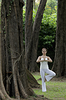 young woman doing yoga under trees - Alex Mares-Manton