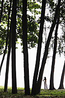 woman wearing white dress standing under trees - Alex Mares-Manton