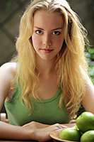 Head shot of blonde young woman with apples - Alex Mares-Manton
