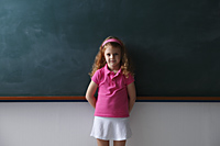 Young girl standing in front of chalkboard - Nugene Chiang