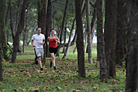 young couple running together through trees - Alex Mares-Manton