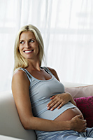 Pregnant woman holding tummy and smiling - Alex Mares-Manton