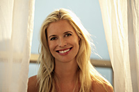head shot of blond woman smiling in front of window - Alex Mares-Manton