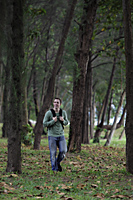 young man wearing back pack walking through forest - Alex Mares-Manton