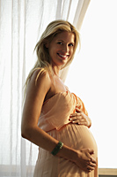 pregnant woman holding her belly and smiling - Alex Mares-Manton